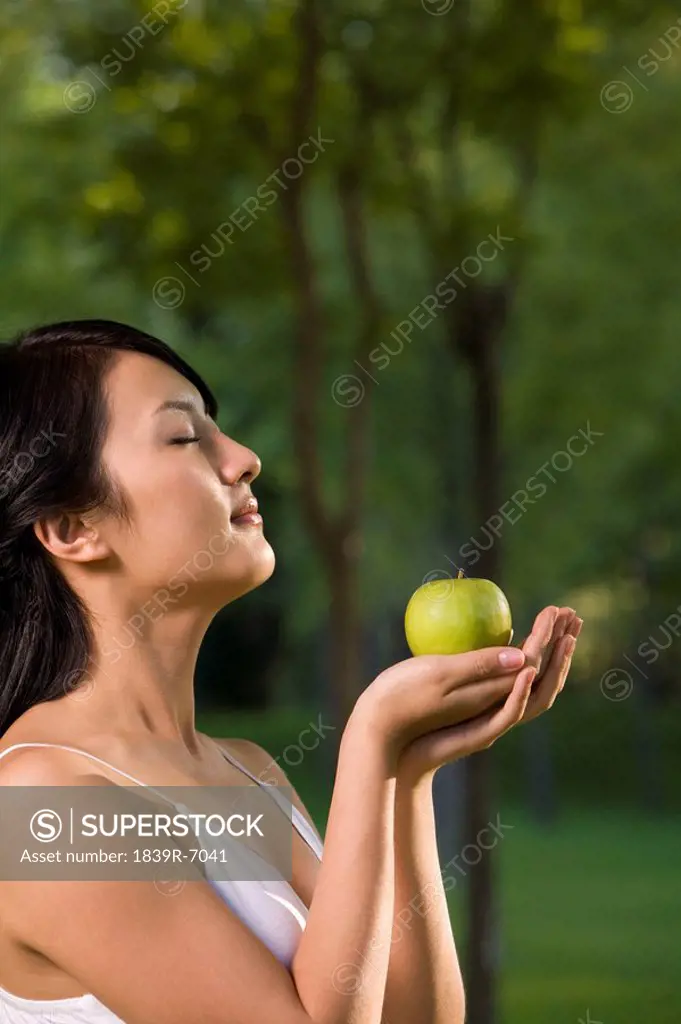 Young woman holds a green apple