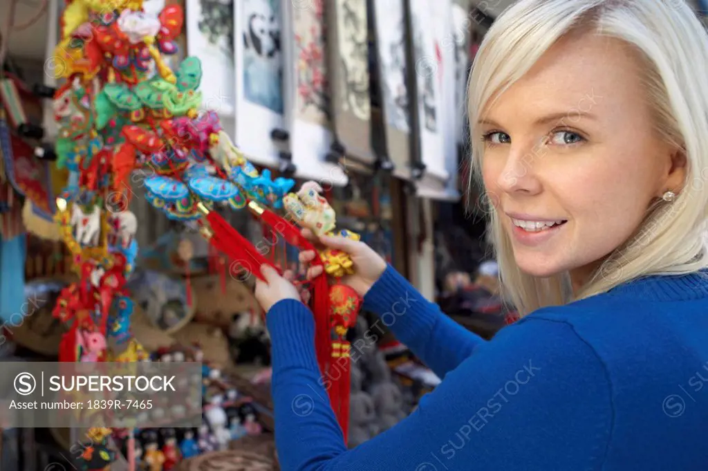 Young woman shops for souvenirs at outdoor market in China