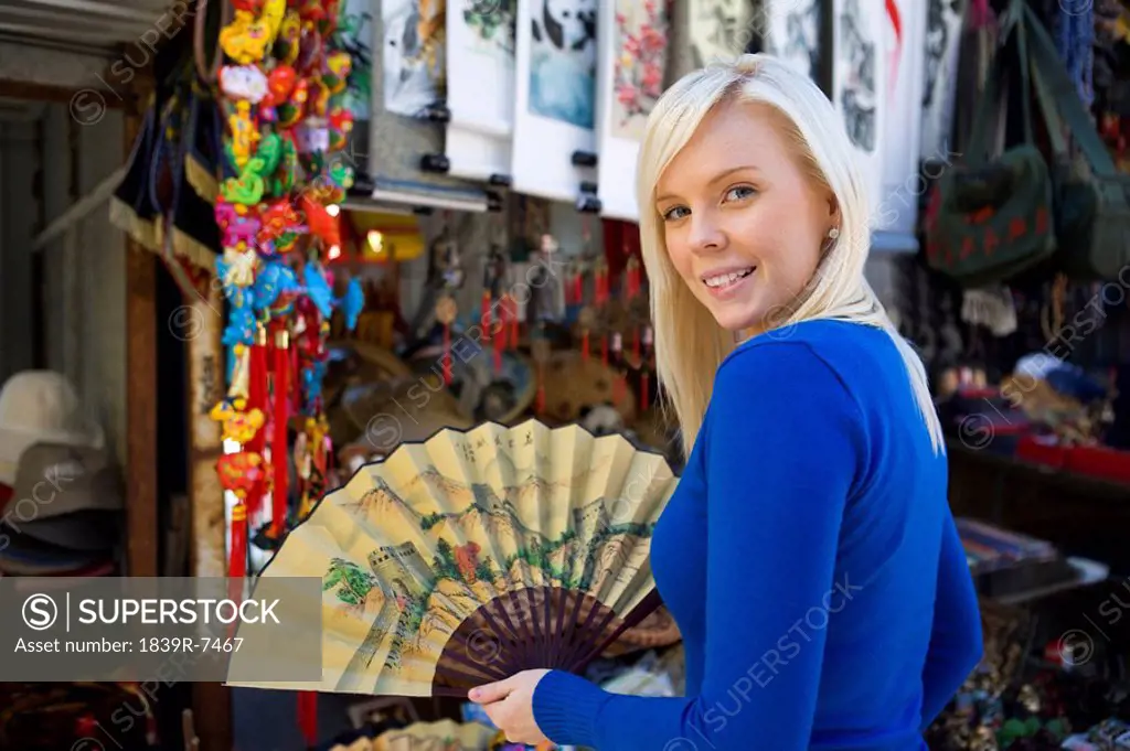 Young woman shops for souvenirs at outdoor market in China