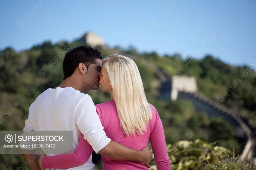 Young couple kiss at the Great Wall of China