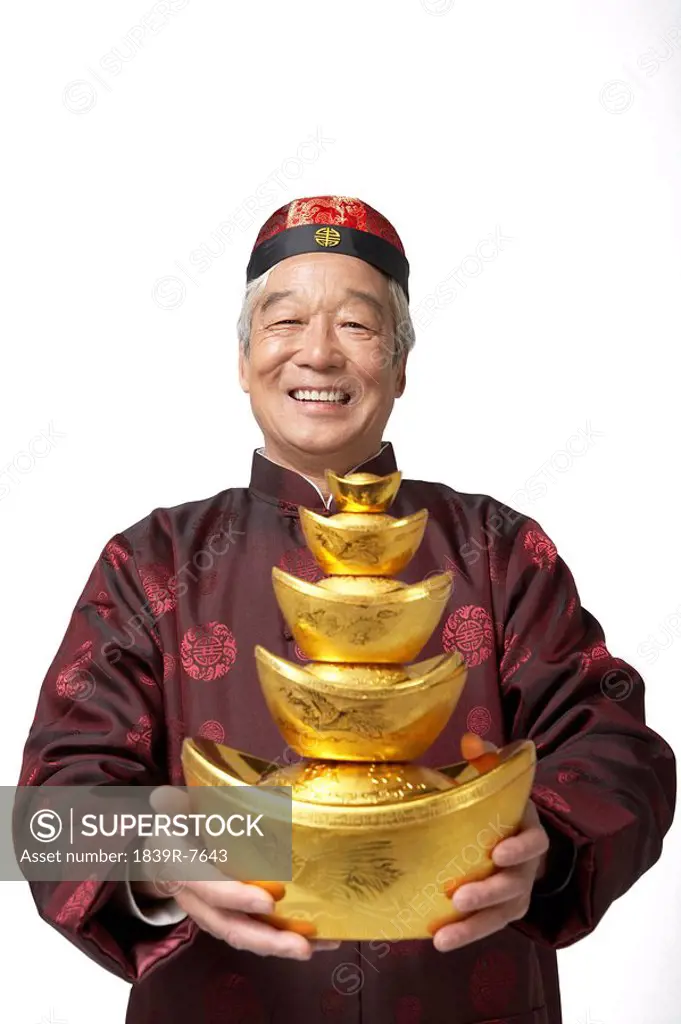 An elderly gentleman holds gold as a symbol of wealth and prosperity for Chinese New Year