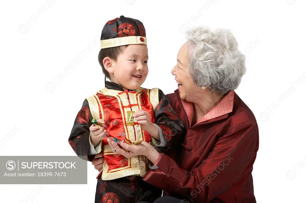 A grandmother shares candy with her grandson on Chinese New Year