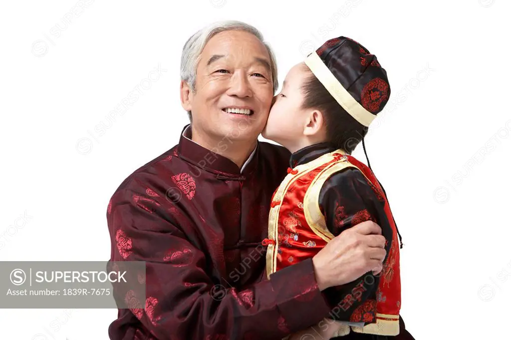 A grandson kisses his grandfather´s cheek