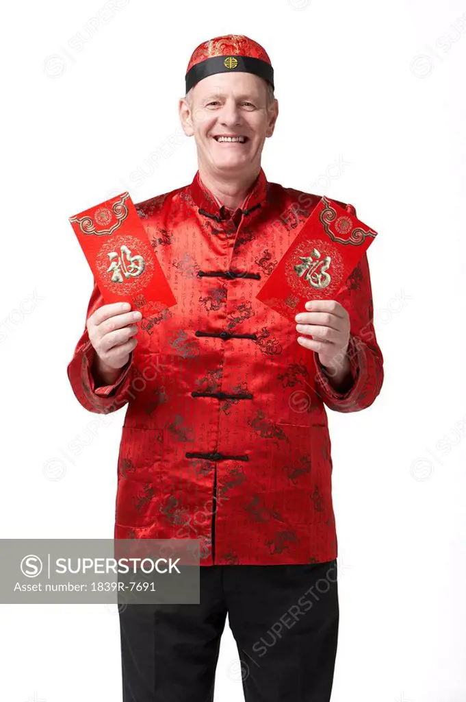 A man holds dressed for Chinese New Year holds out red envelopes