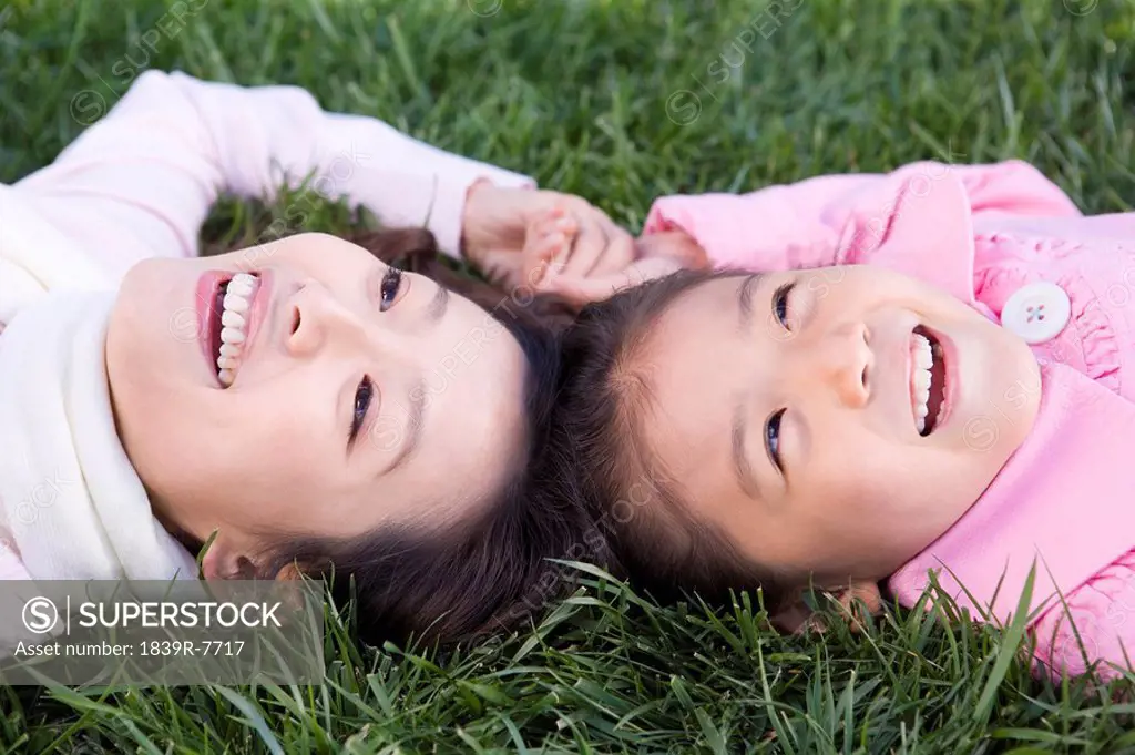 A mother and daughter lie in the grass