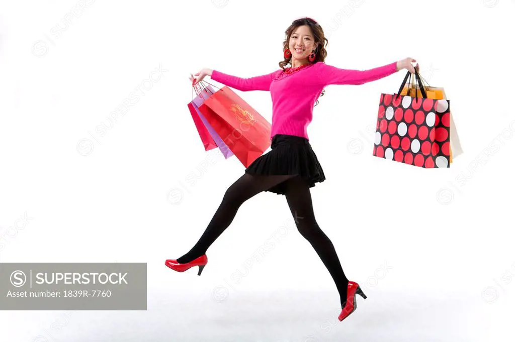 Young woman skipping with her shopping bags