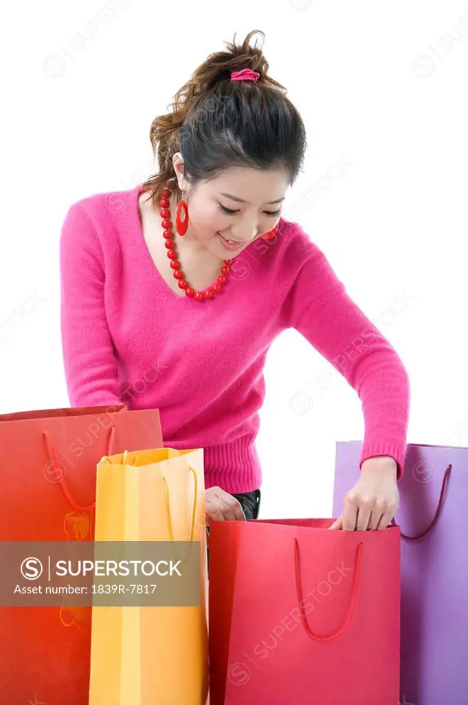 Young woman looking through shopping bags