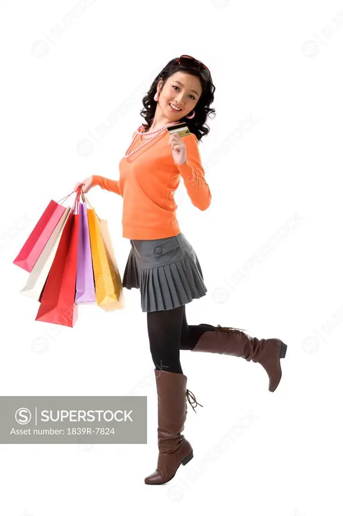 Young woman with credit card holding shopping bags