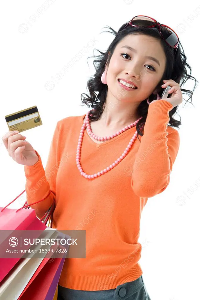 Young woman with credit card holding shopping bags