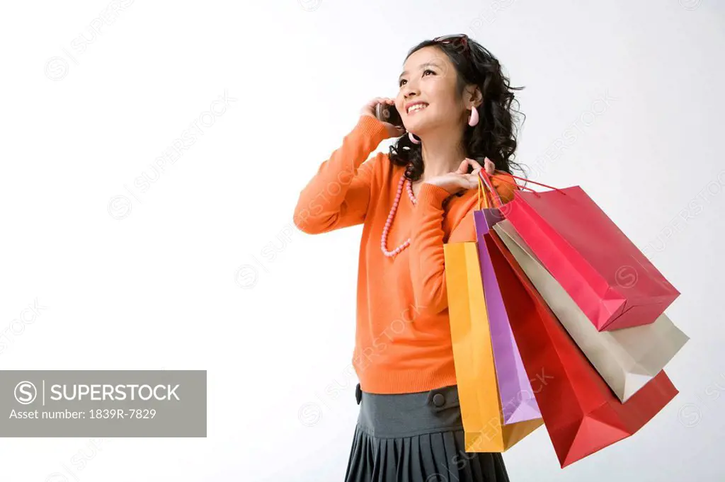 Young woman with shopping bags talking on her mobile phone