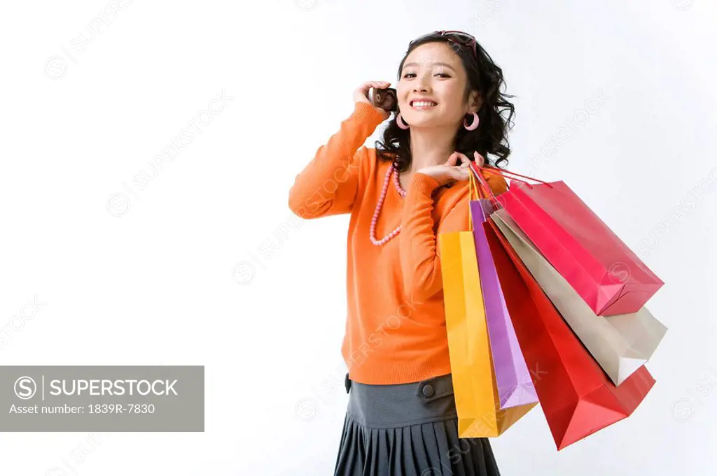 Young woman with shopping bags talking on her mobile phone