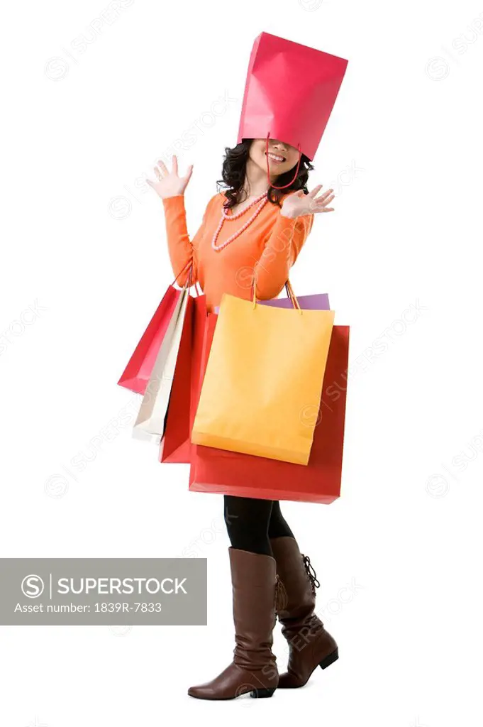 Young woman with shopping bag over her head
