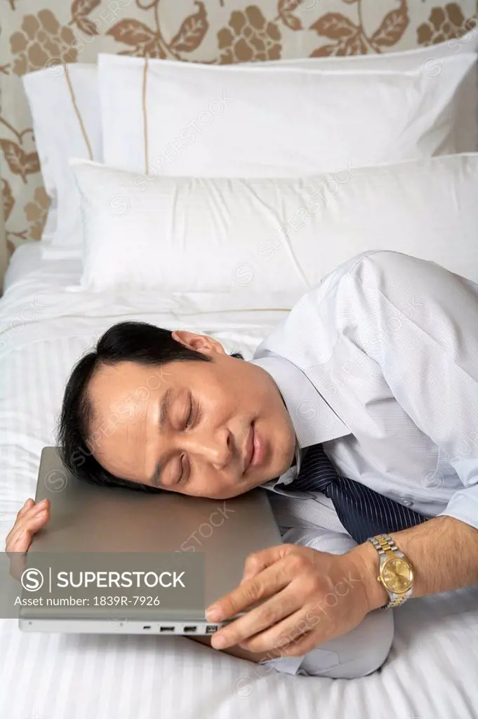 Man sleeping on top of his laptop
