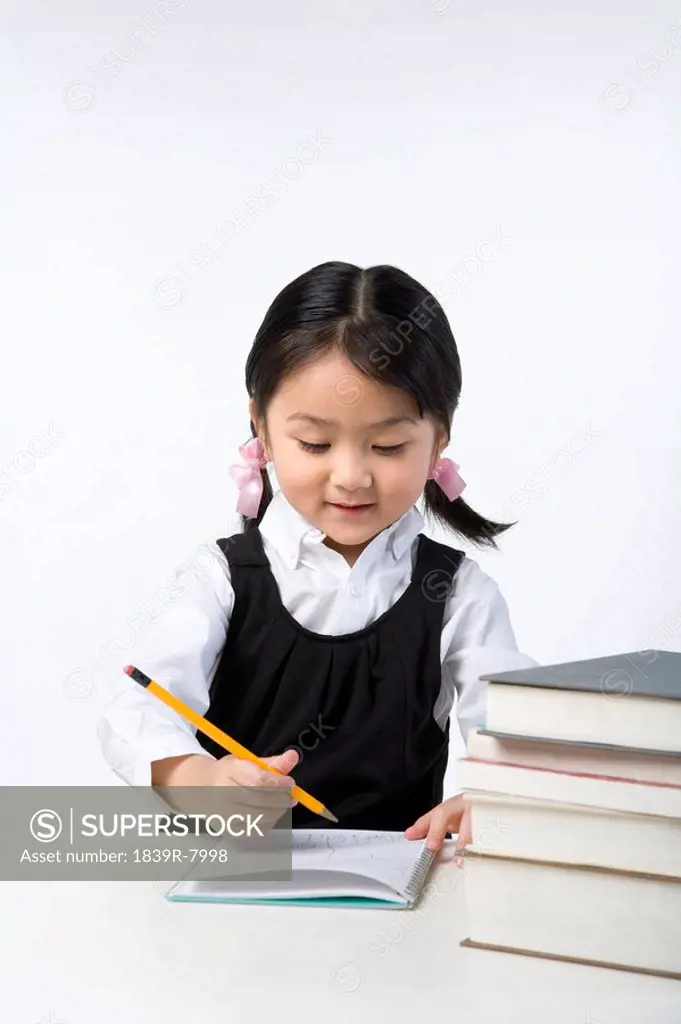 Little girl writes on a notebook