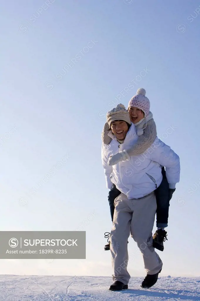 Young man carrying a young woman piggyback