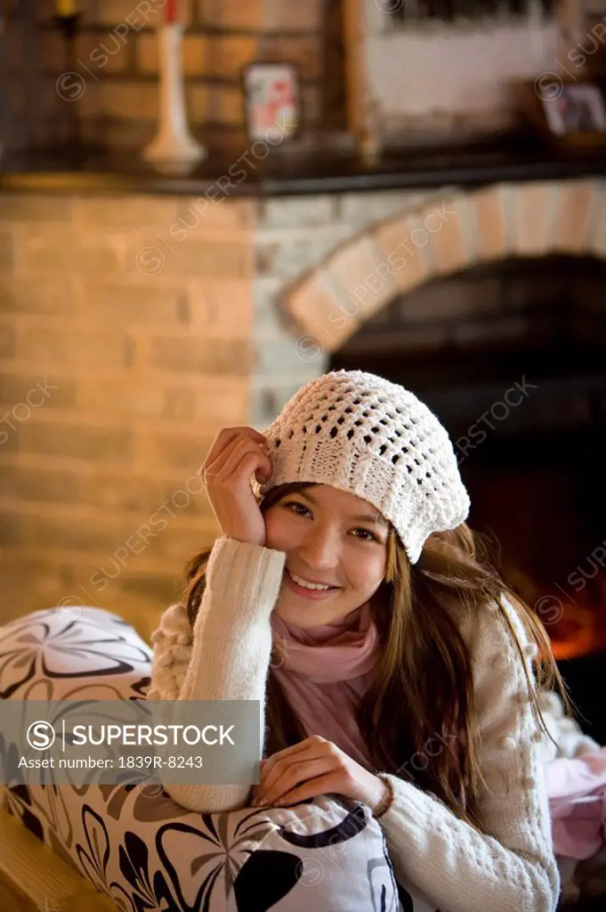 Young woman smiling in front of a fireplace