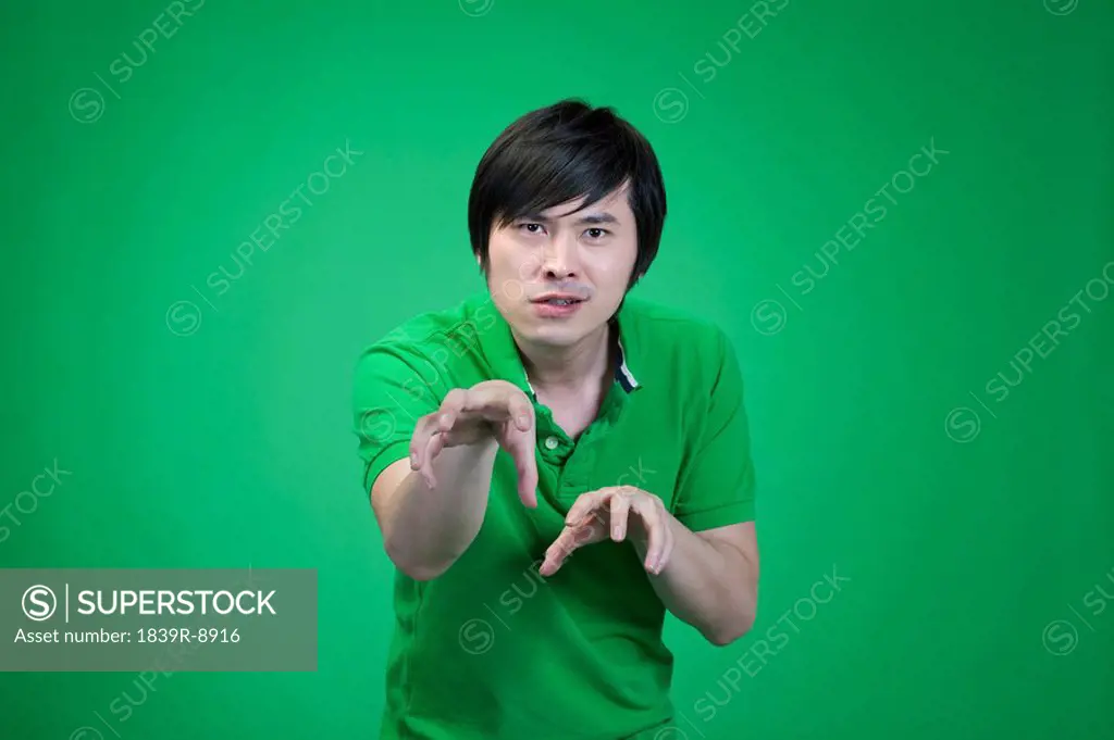 Man in green on green background practicing kung fu