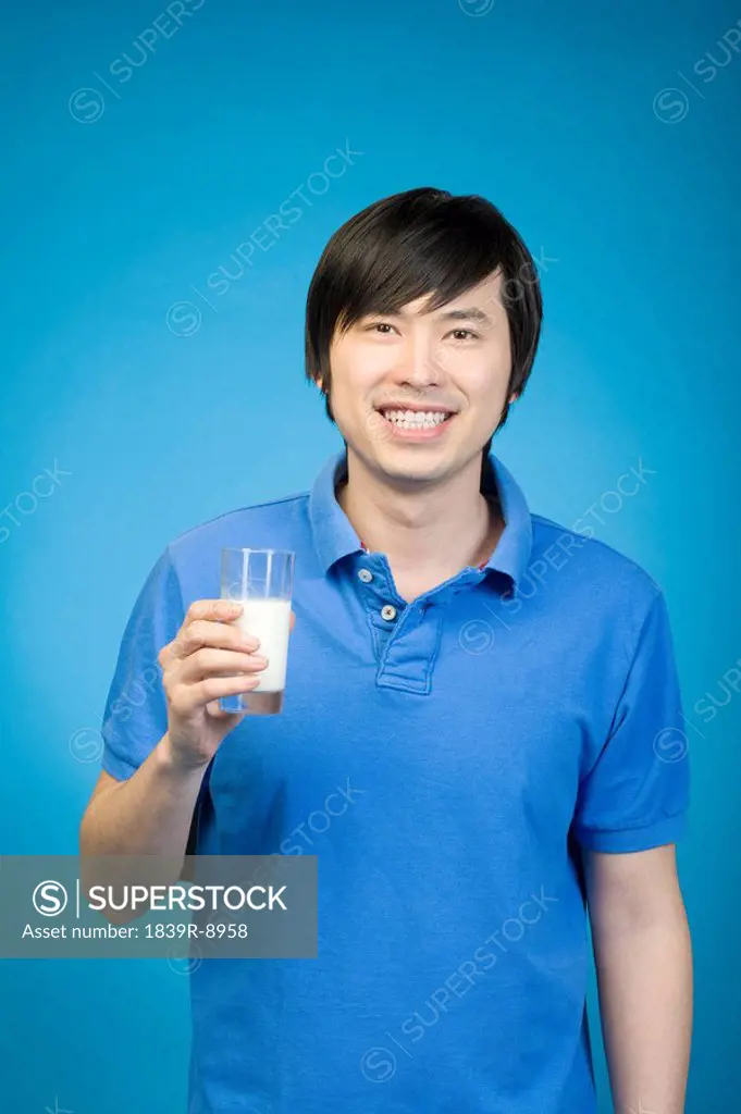 Man in blue drinking milk on blue background