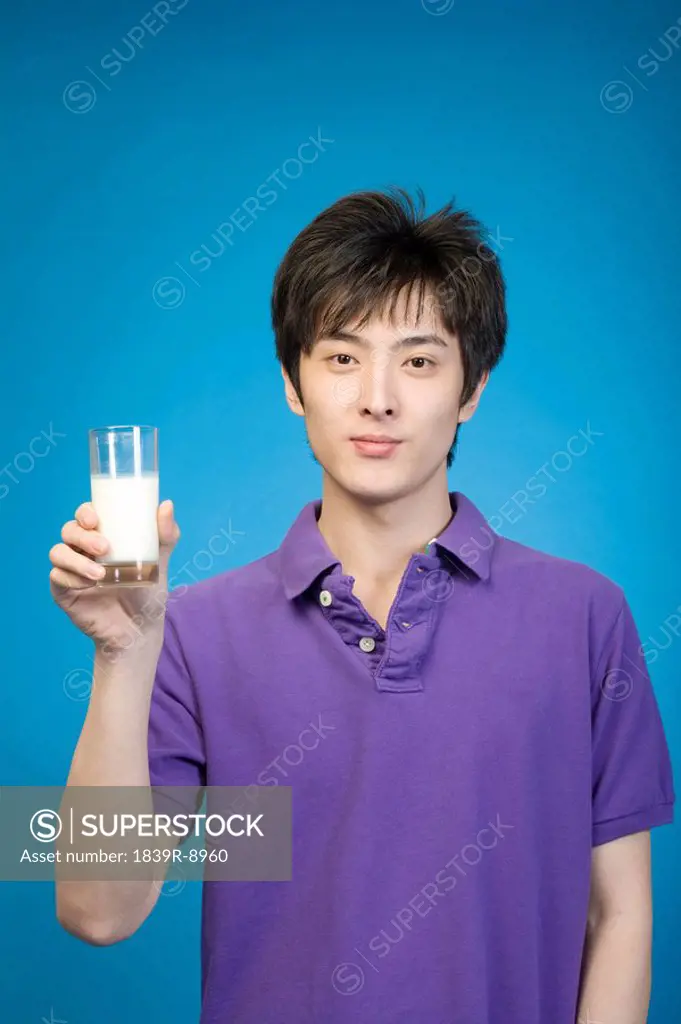 Man drinking milk on blue background