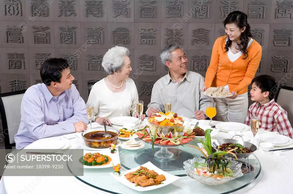 Mother serves dumplings to Grandparents, Husband and Son