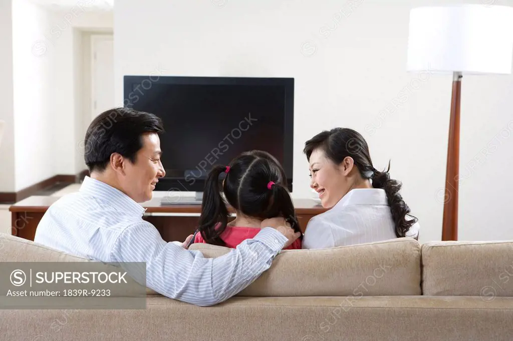 Couple with child in front of widescreen television