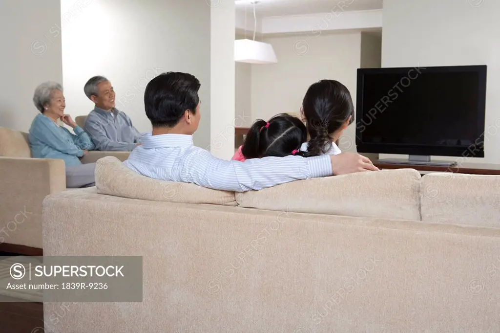 Family watching widescreen televisioin