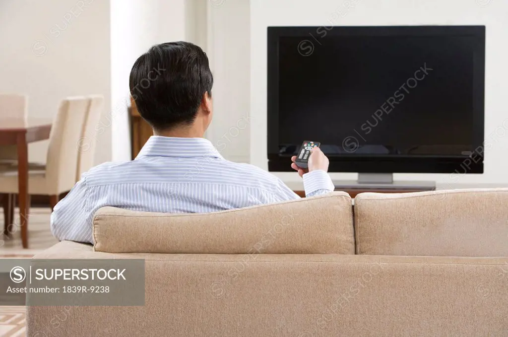 Man watching widescreen television