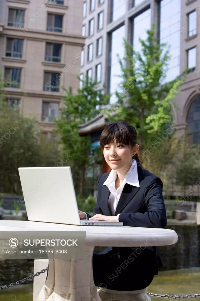 Businesswoman outside on laptop