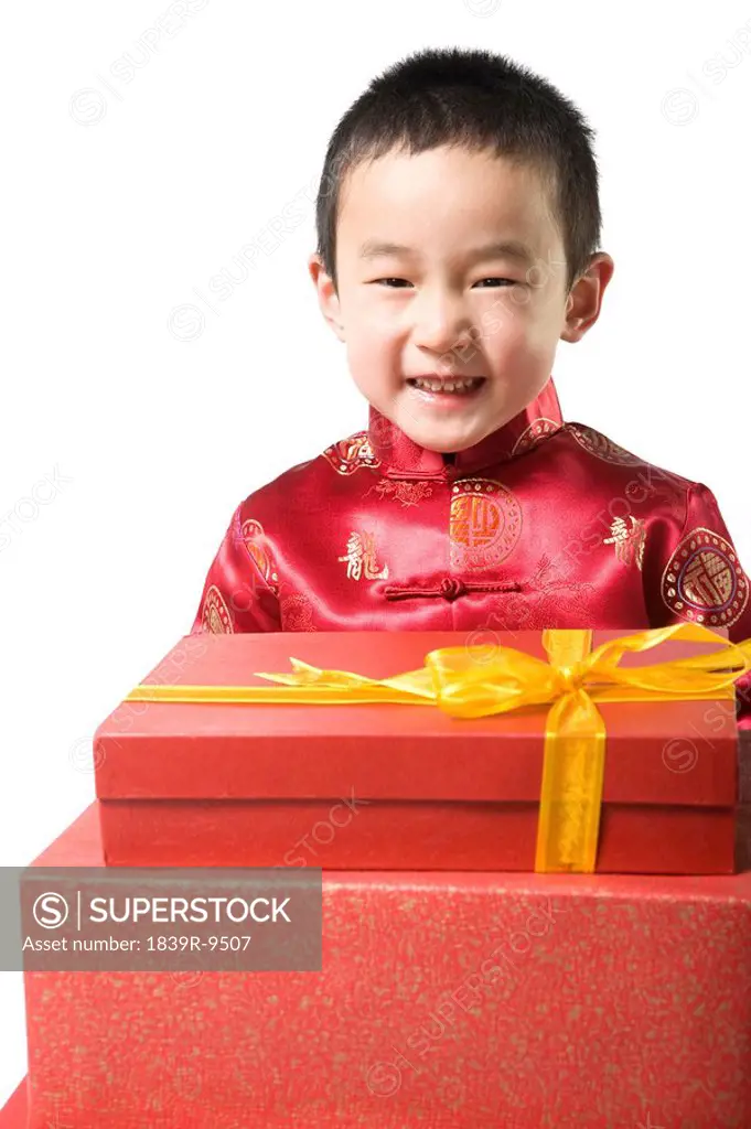Boy in Chinese traditional clothes holding gift boxes