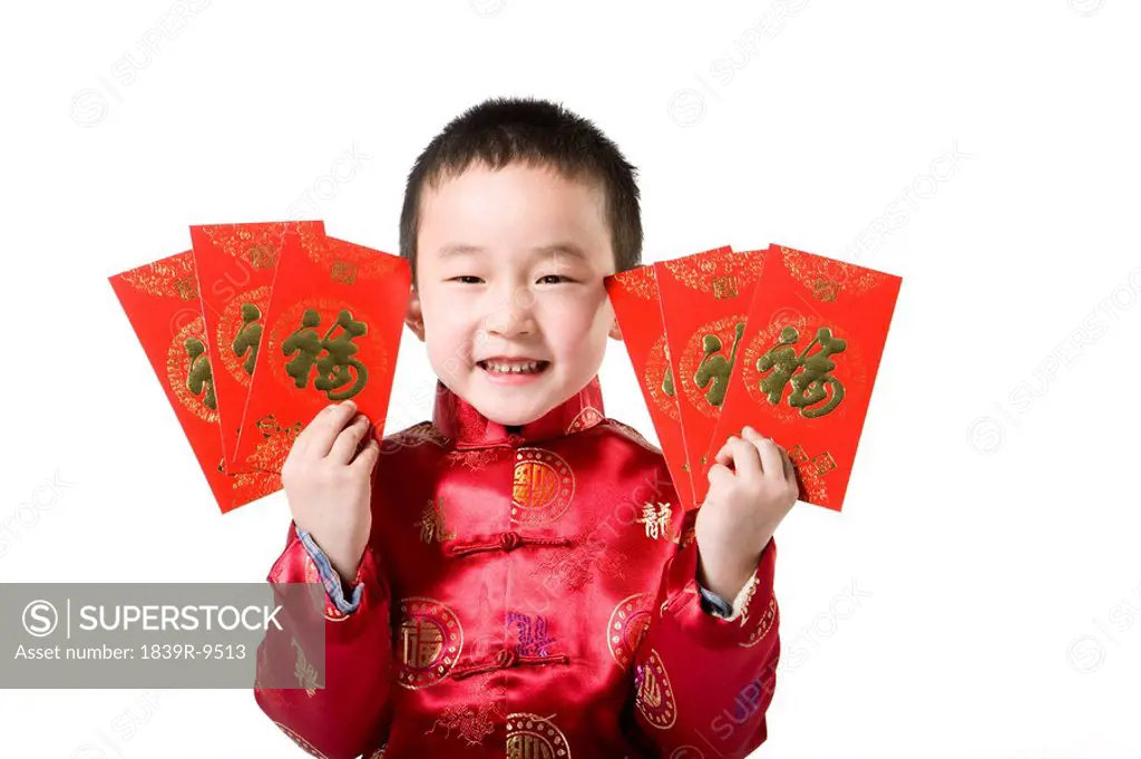 Boy in Chinese traditional clothes holding red envelop