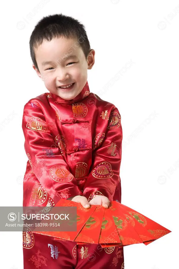 Boy in Chinese traditional clothes holding red envelop