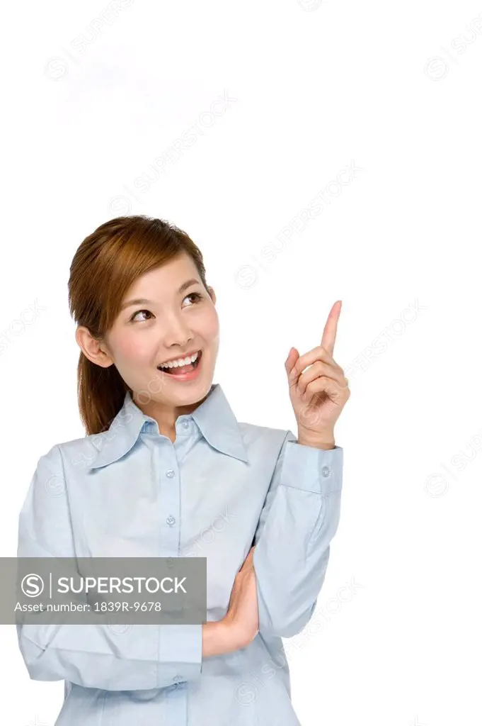 Smiling young businesswoman pointing her finger
