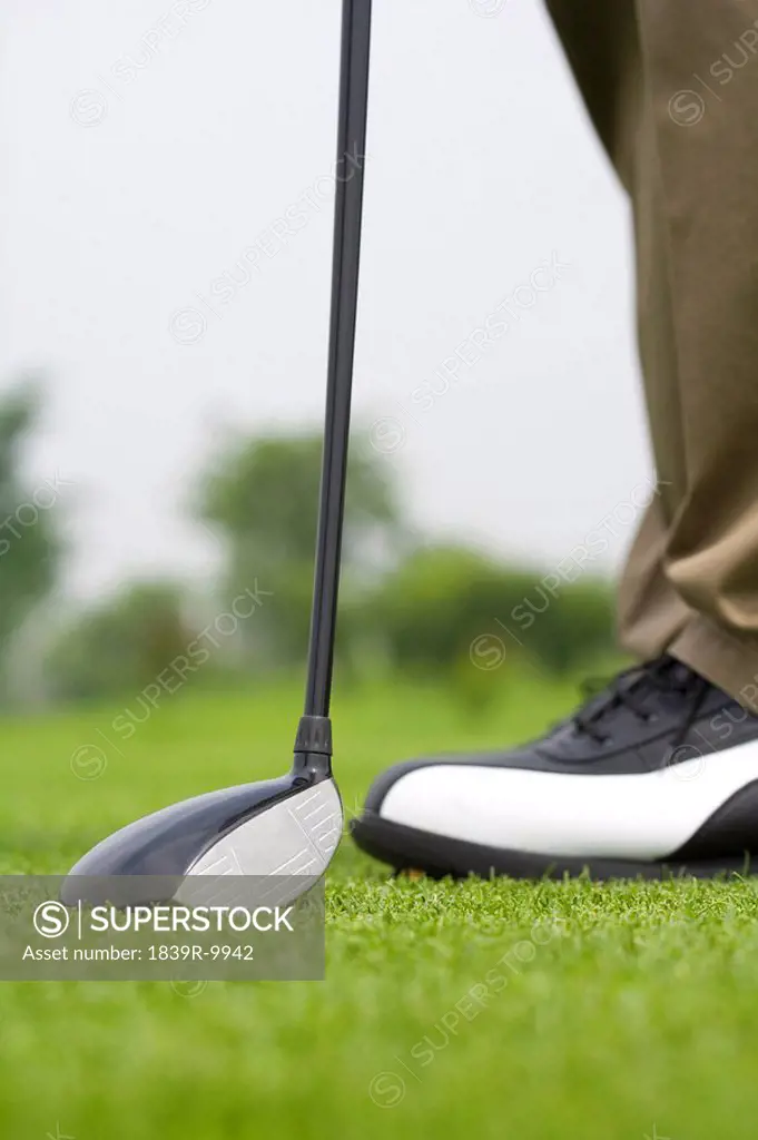Close_up of golf club and golfer´s feet