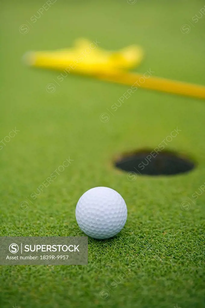 Close_up of golf ball by hole
