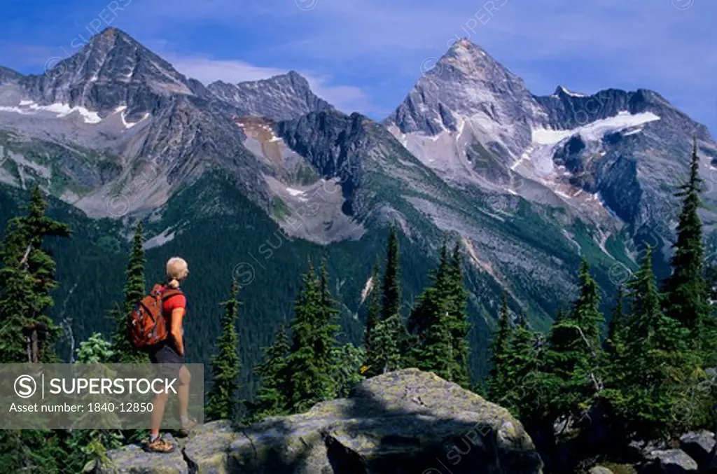 Woman hiking along the Abbott Ridge Trail looking at Mount Sir Donald in Glacier National Park, British Columbia, Canada.