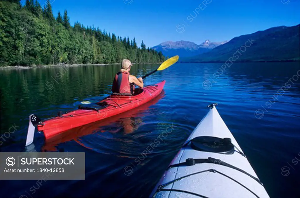 Kayaking on Clearwater Lake with Huntley Peak on the horizon in Wells Gray Provincial Park, British Columbia, Canada.