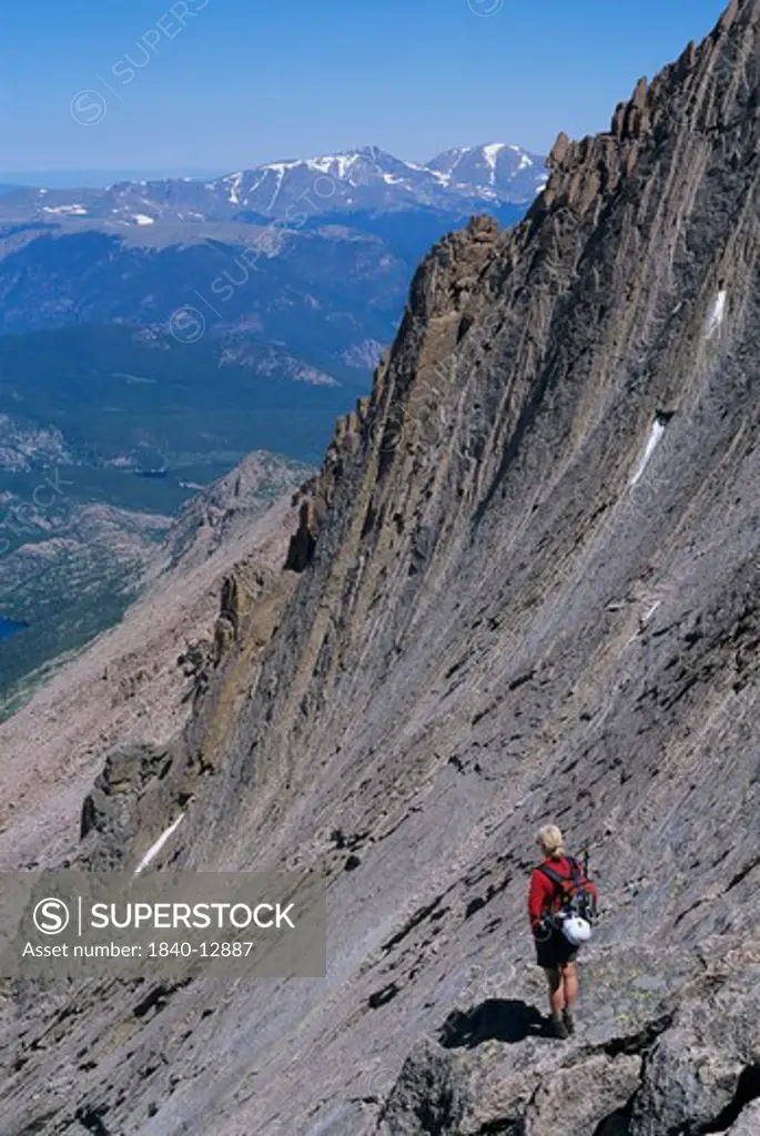 A climber stands high on the side of Long's Peak at the top of ""The Trough"" in Rocky Mountain National Park, Colorado.