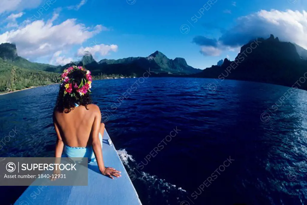 Tahitian girl on bow of boat in Cook's Bay on the island of Moorea, Society Islands, French Polynesia.