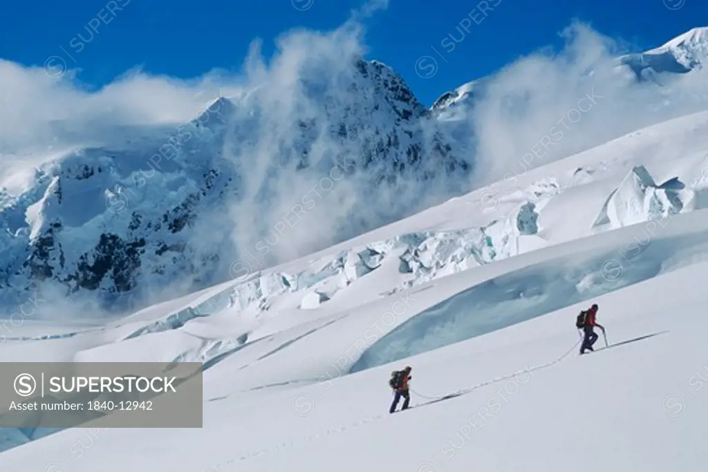 Two mountaineers ascend the Tasman Glacier below Mount Green in Mount Cook National Park, Southern Alps, South Island, New Zealand.