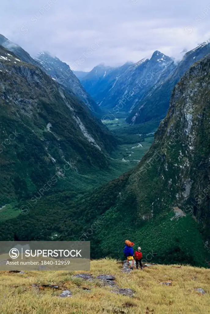 Two trekkers pause near the top of Mackinnon Pass along the Milford Track for a view down the Clinton Valley in Fiordland National Park on the South Island of New Zealand.