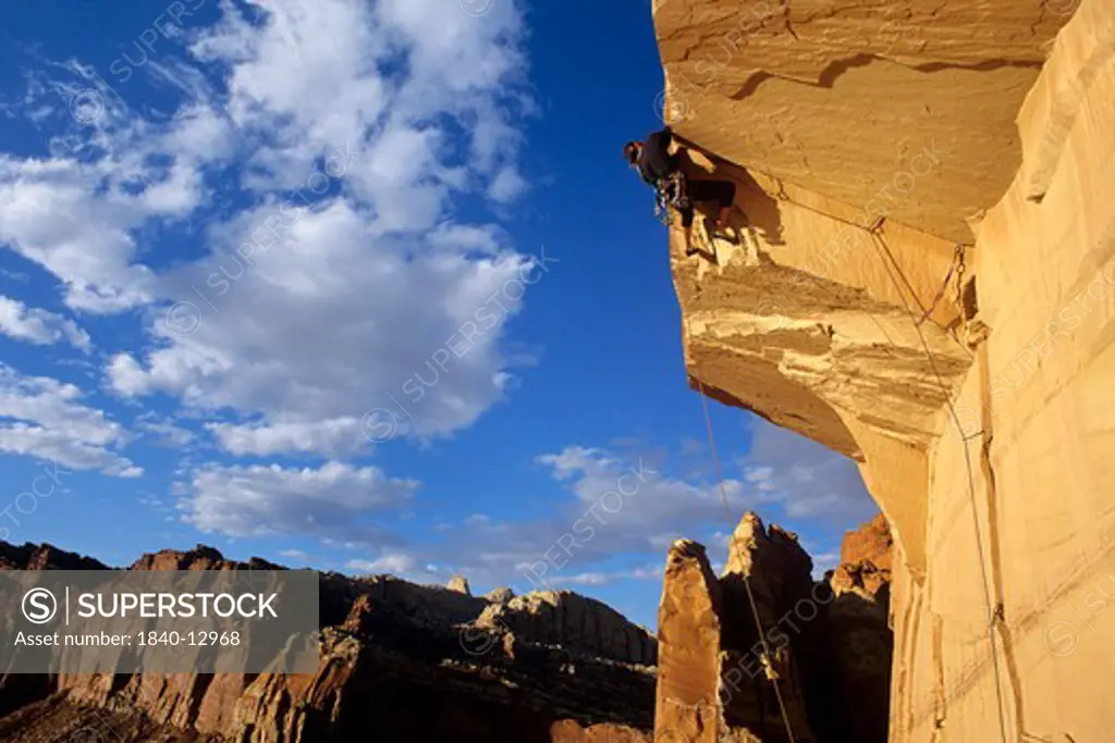 Rock climber pulls over ""Capitol Roof"" above Torrey in Capitol Reef National Park, Utah.