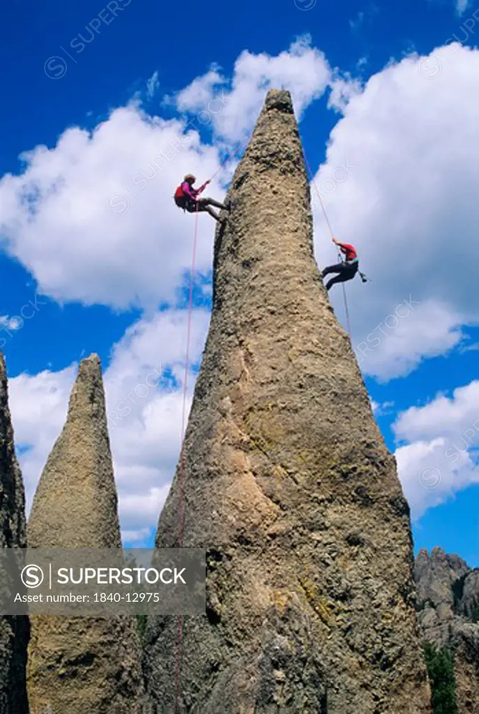 Two men rappelling from a rock spire in The Needles area in the Black Hills of South Dakota.