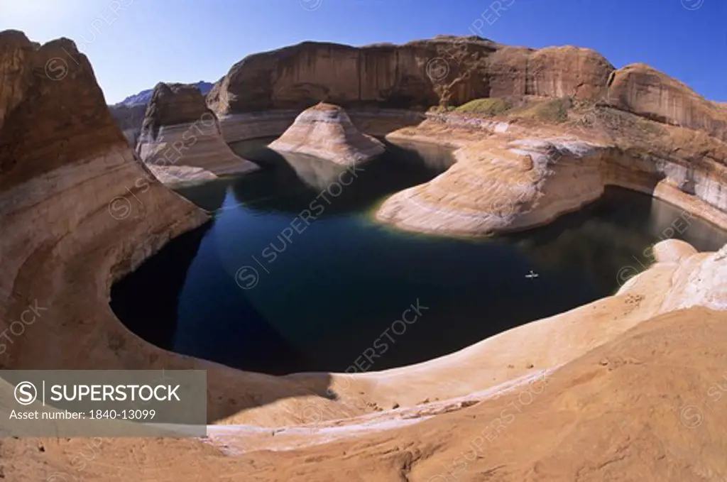 Kayaking (center right) on Lake Powell in Reflection Canyon beneath the reservoir's 110-foot tall ""bathtub ring"".