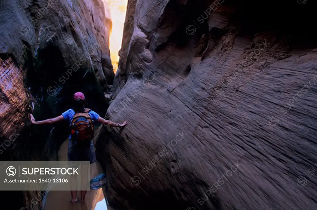 A hiker in recently scoured-out narrows along Twilight Canyon at a location once 110 feet below the surface of Lake Powell.