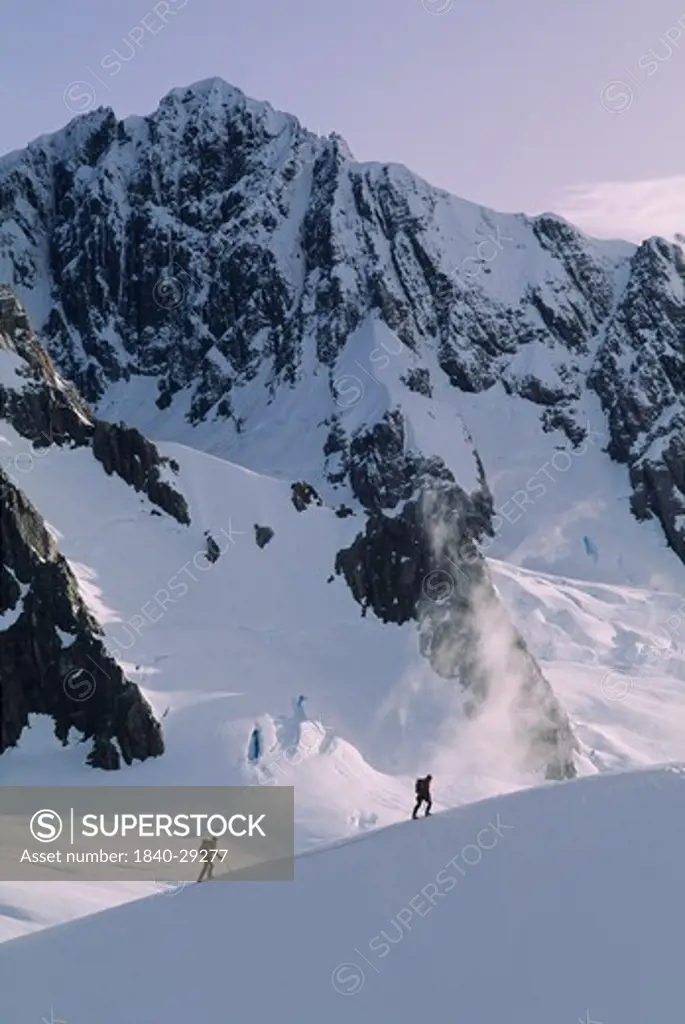 Two climbers below Mount Haasts on Fox Glacier in Westland National Park, South Island, New Zealand.