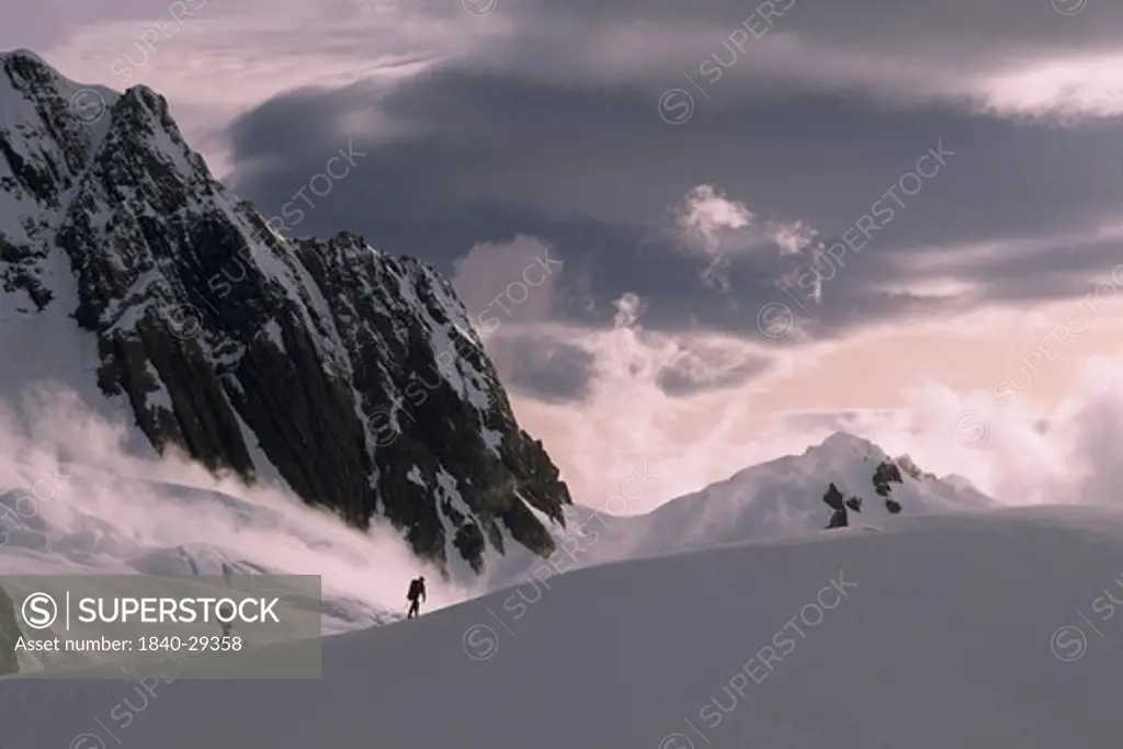 Two mountaineers below The Buttress on Fox Glacier, Westland National Park, Southern Alps, South Island, New Zealand.