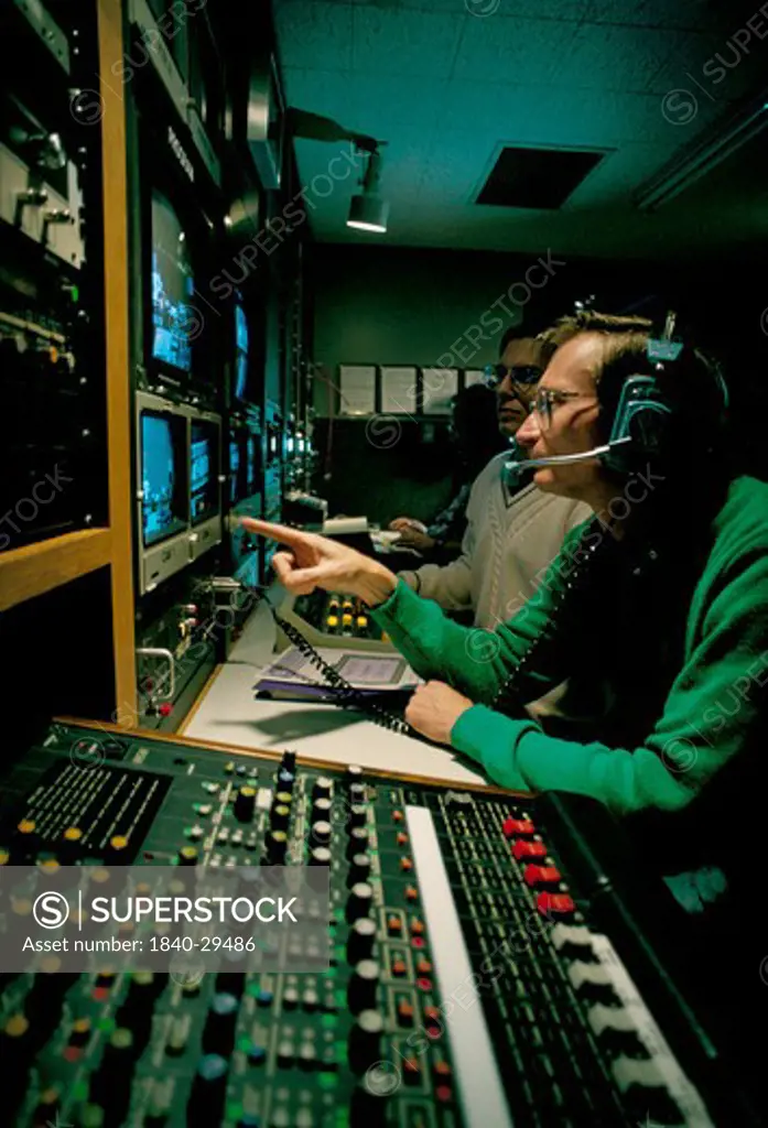Men working in a TV station control room.