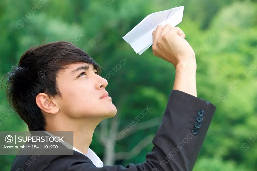 Businessman holding toy airplane, profile