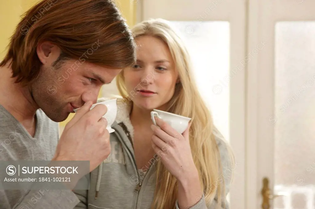 Young couple drinking coffee in kitchen