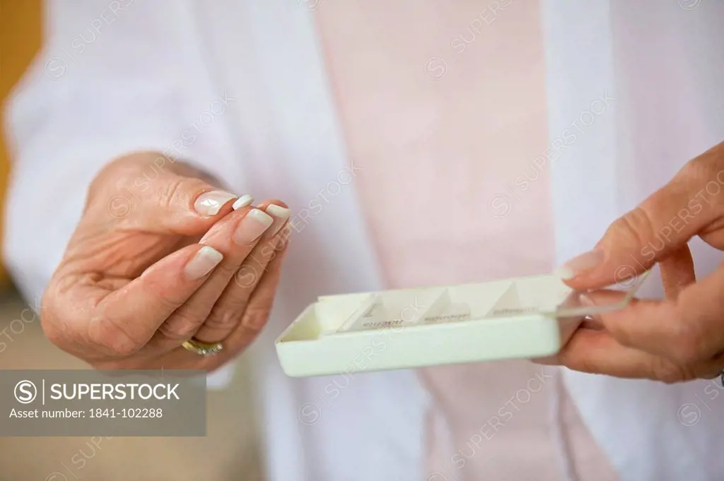 Senior woman taking pill, close_up